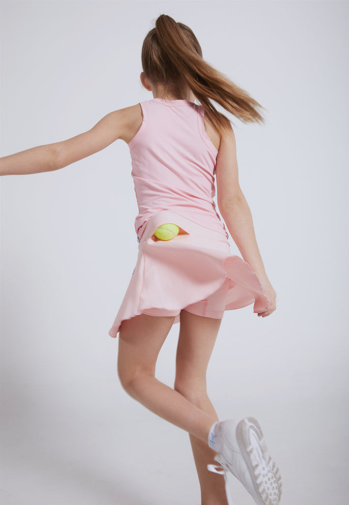 Mädchen dreht sich im rosanen Tennisrock