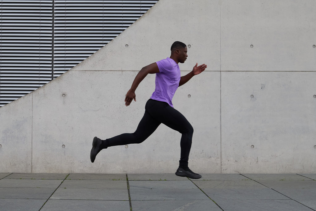Rennender Mann mit lilafarbenem Shirt und schwarzer Tights von Sportkind