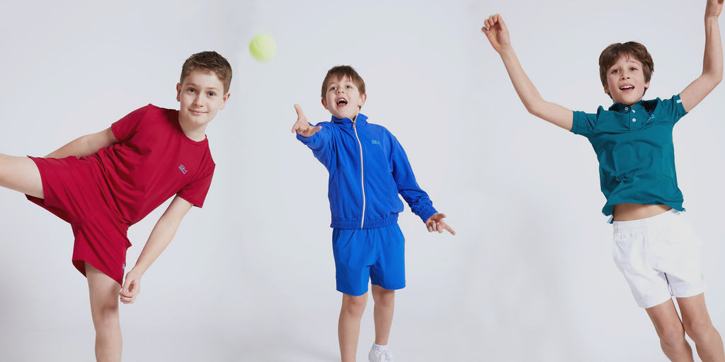 Drei Jungen im Sportkindoutfit freuen sich